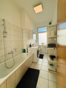 什未林Attraktive Wohnung im schönen Hinterhof的带浴缸和洗衣机的浴室。