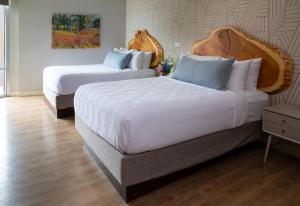 特拉弗斯城Delamar Traverse City的酒店客房,配有两张带白色床单的床