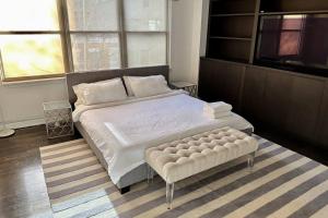 纽约Private Penthouse w Roof Oasis的一间卧室配有一张大床和一张搁脚凳