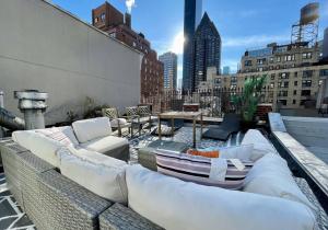 纽约Private Penthouse w Roof Oasis的一座大楼内一个带沙发和桌子的屋顶露台