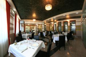 巴亚马雷塞内卡酒店的用餐室配有白色桌子和黑色椅子