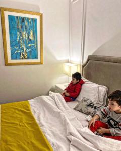 拉合尔Rosewood Lahore的两个男孩坐在床上