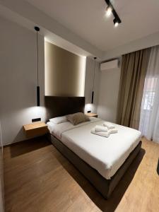 拉米亚La Maison Luxury的一间卧室配有一张带两盏灯的大型白色床。