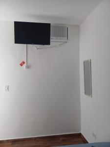 大普拉亚Pousada Believe的挂在白色墙壁上的平面电视