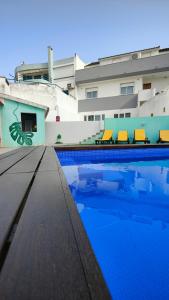 沙尔内卡Villa Paraíso da Caparica的大楼前的蓝色海水游泳池