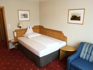 霍赫斯特代林德酒店的酒店客房,配有一张床和一张蓝色椅子