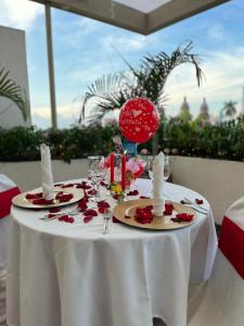 巴兰卡韦梅哈Hotel San Carlos的一张桌子,上面有白色的桌布,上面有玫瑰花