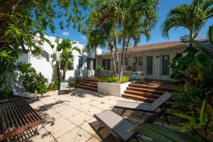好莱坞Casa Del Mar Master的一个带椅子的庭院和一座棕榈树房子