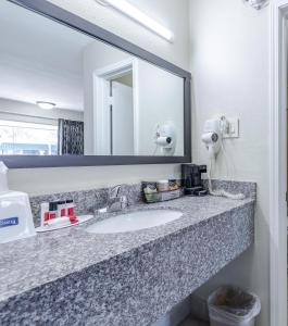 杰克逊Travelodge by Wyndham Jackson North的浴室的柜台设有水槽和镜子