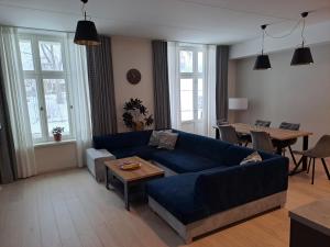 塔尔图Aleksi Apartments的客厅配有蓝色的沙发和桌子