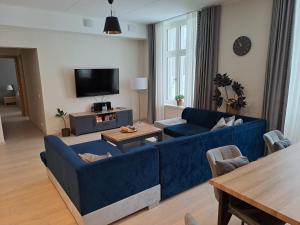 塔尔图Aleksi Apartments的客厅配有蓝色的沙发和桌子