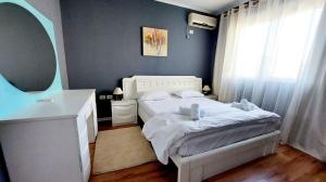 地拉那Signature Idea hotel的卧室配有白色的床和镜子