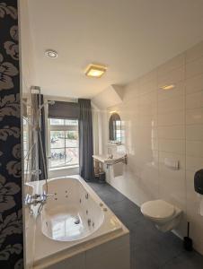 迪尔斯泰德附近韦克Hotel 1851的白色的浴室设有浴缸和卫生间。
