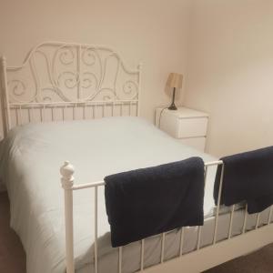 卡迪夫1 Bed Apartment in Cardiff Bay -Dixie Buildings的卧室配有白色床和黑色毛巾