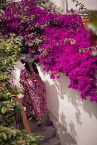 丽江丽江百花谷客栈的穿着裙子和帽子的女人,在楼梯上带着粉红色的花朵