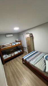 塞尔苏拉穆斯州长镇CASA DE PRAIA -Palmas Governador Celso Ramos, Sc的一间卧室配有两张双层床。