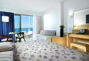 赫索尼索斯信天翁Spa度假酒店的酒店客房设有床和客厅。
