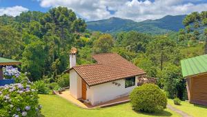 蒙特韦尔迪Chalés Mirante das Pedras的一座小房子,位于一个山地花园内