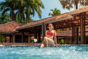比亚维森西奥Tequendama Hotel Campestre Villavicencio的坐在游泳池里的比基尼女人