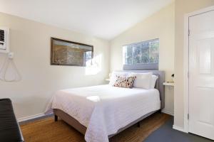 圣安东尼奥Marfa - A Birdy Vacation Rental的一间卧室设有一张床和两个窗户。