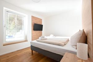 拉赫塔尔Arton Lachtal - Apartments Steiermark的白色的卧室设有床和窗户