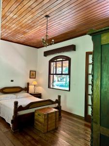 阿蒂巴亚Sítio Mato Dentro的一间卧室设有一张床和木制天花板