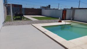 罗萨里奥De leon的一座小游泳池,位于一座建筑的一侧