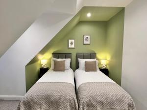 博勒姆伍德2-bed flat in central Borehamwood location的绿墙客房内的两张床