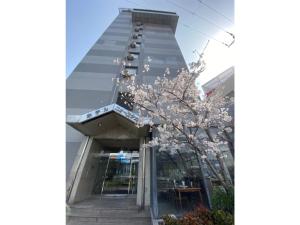 泉佐野Hotel New Yutaka - Vacation STAY 35266v的前面有一棵开花的树