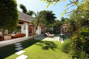 塞米亚克巴厘阿斯里别墅酒店的一个带游泳池和房子的后院