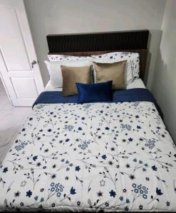 松索纳特Marhabibi's home的一张带蓝色和白色棉被和枕头的床