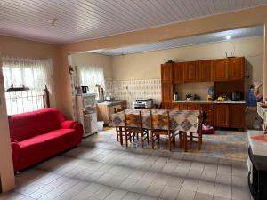 因贝Casa albatroz Imbé的一间厨房,里面配有红色的沙发和一张桌子