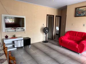 因贝Casa albatroz Imbé的客厅配有红色沙发和平面电视