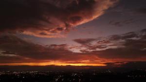 阿拉胡埃拉香达利度假酒店&Spa的天空阴云的城市上空的日落