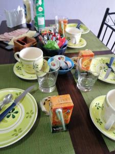 蓬塔阿雷纳斯Casa Celeste的一张桌子上放着黄盘和杯子