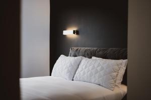 南安普敦Luxury Apartment by Ocean Village Marina的一张铺有白色床单的床和墙上的灯