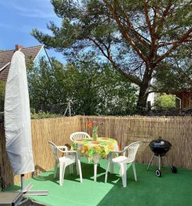岑平Ferienwohnung Flunder的草坪上设有桌椅和烧烤架