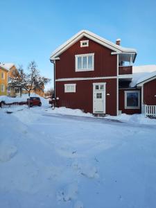 基律纳Kiruna accommodation Gustaf wikmansgatan 6b (6 pers appartment)的雪中带白门的红色房子