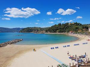 阿梅利亚International Holidays Luxe House Pool Beach-Lerici-Cinque Terre-Liguria Case Vacanze in Touristic Village River的海滩上摆放着椅子,水里人