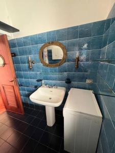 卡莫利La casa del marinaio的蓝色瓷砖浴室设有水槽和镜子