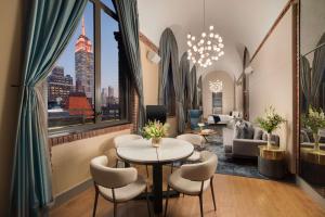 纽约NH Collection New York Madison Avenue的酒店大堂设有桌椅,享有城市美景。