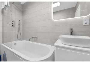 伦敦Lovely 4 bedroom with Outdoor space!的白色的浴室设有浴缸和水槽。