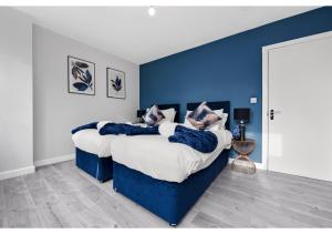 伦敦Lovely 4 bedroom with Outdoor space!的一间卧室设有两张带蓝色墙壁的床