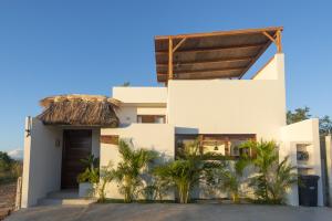 埃斯孔迪多港La petite Casa - Luxury home close to La Punta的一座棕榈树掩映的白色房子