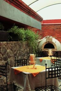 科利马Hotel Art Gallery Casona de los Milagros的露台上的户外桌子和比萨饼烤箱