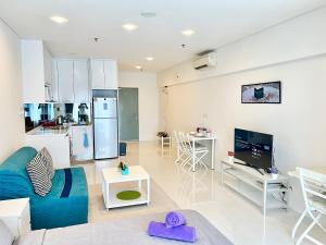 吉隆坡Summer suites KLCC by cozy stay的一间带蓝色沙发的客厅和一间厨房