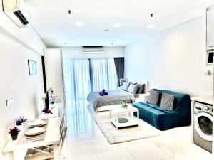 吉隆坡Summer suites KLCC by cozy stay的客厅配有床和沙发