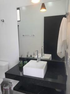 圣若昂-巴蒂斯塔-杜格罗里亚Pousada Lobo Guará的浴室设有白色水槽和镜子