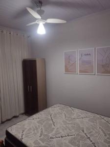 南圣弗朗西斯科casa aconchegante em Ubatuba的一间卧室配有一张床和吊扇