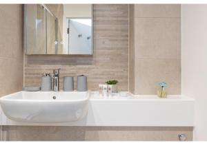 贝肯翰姆Beckenham Beauty: Modern 1-Bedroom Abode的浴室设有白色水槽和镜子